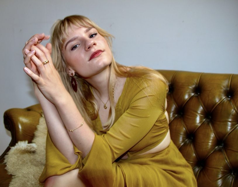 Saskia sitzt auf einem Ledersofa.