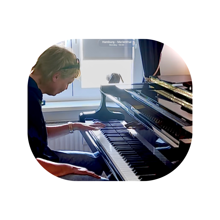 Mann sitzt an einem schwarzen Flügel und spielt Klavier